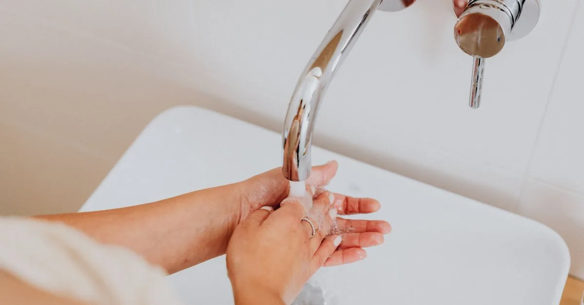 Persona lavándose las manos en un lavabo limpio