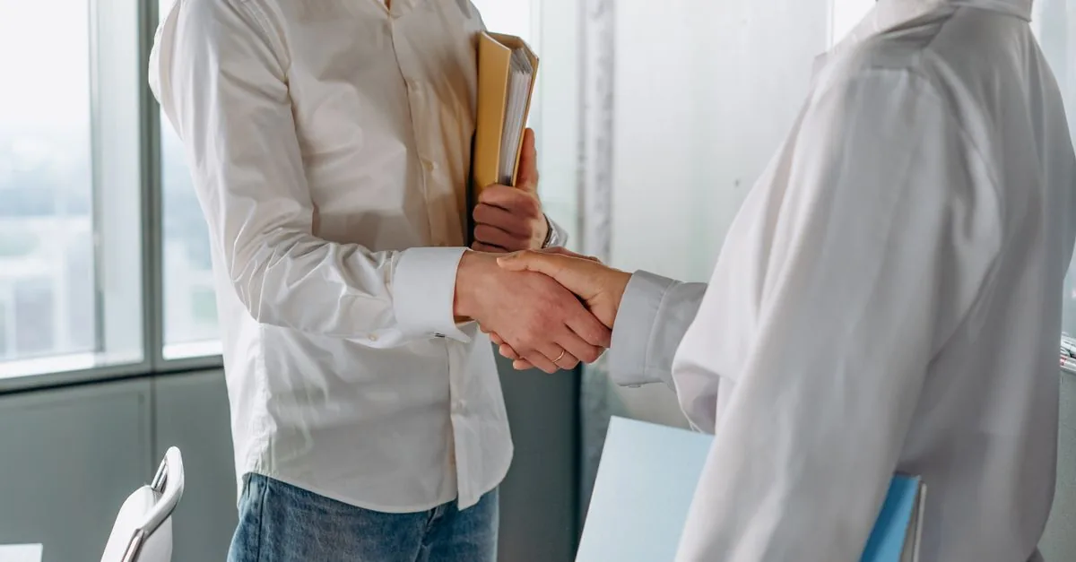 Apretón de manos entre dueño y cliente en un negocio pequeño