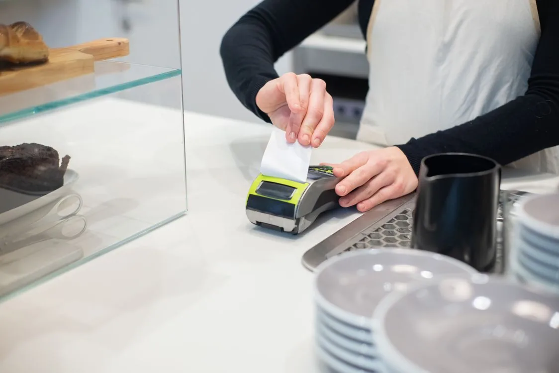 Caja registradora y etiquetas de precio en una tienda local