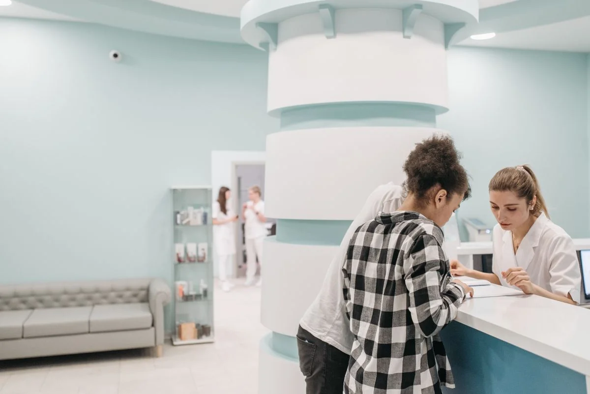 Recepción de clínica médica atendiendo pacientes