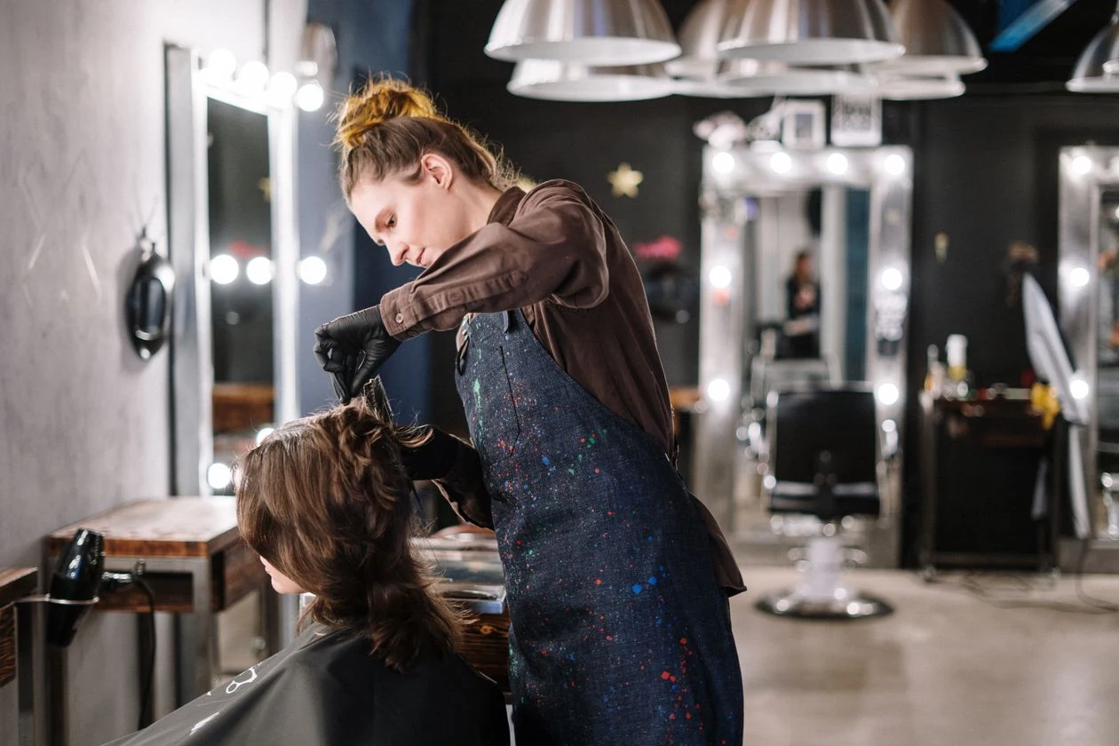 Estilista trabajando en el cabello de una clienta en el salón