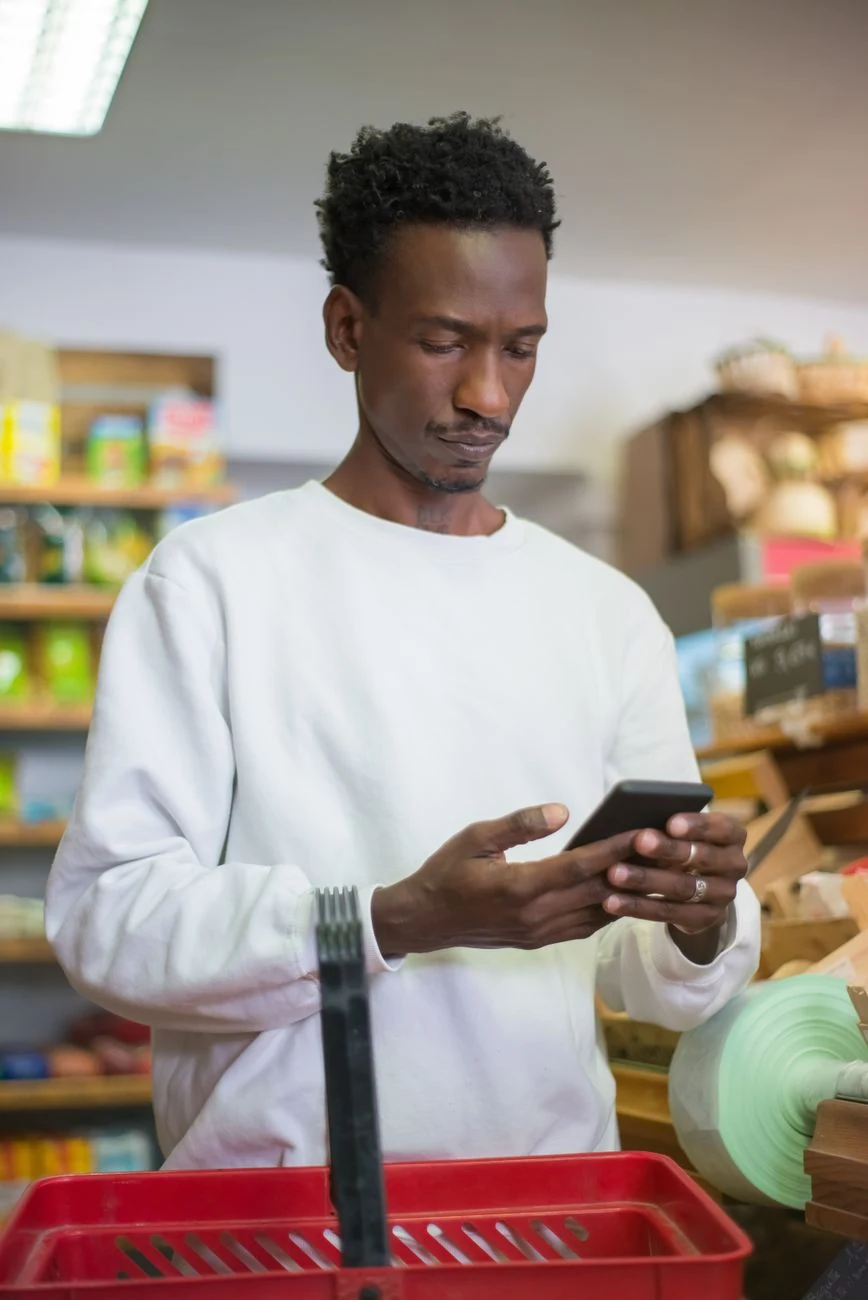 Dueño de tienda revisando su teléfono con calma