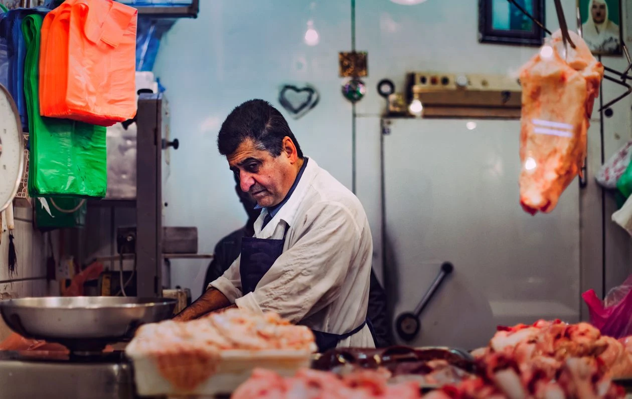 Carnicero cortando carne fresca en su carnicería