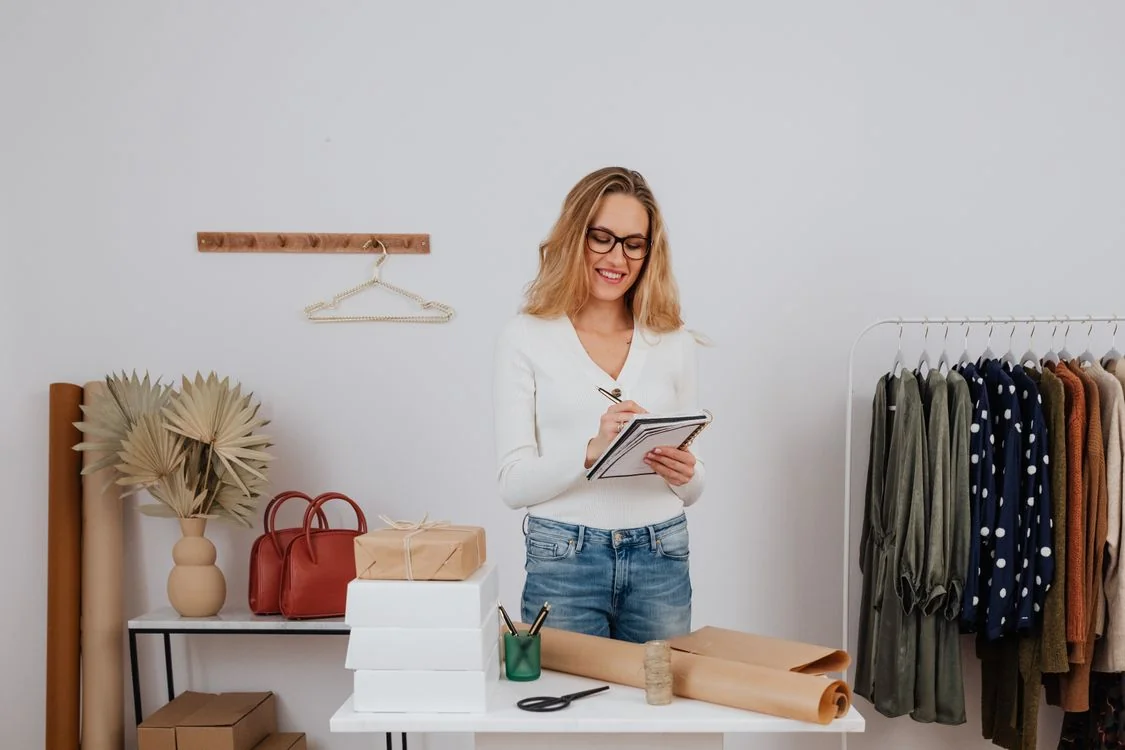 Dueña de boutique trabajando en su tienda, acomodando la mercancía