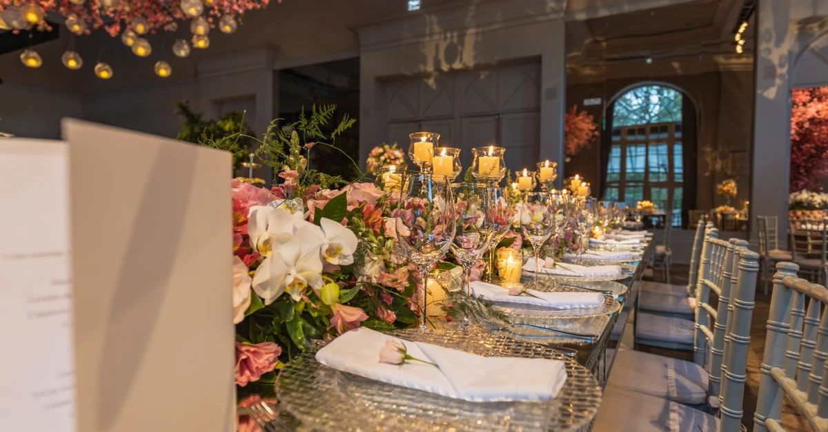 Mesa larga de recepción de boda con flores y velas