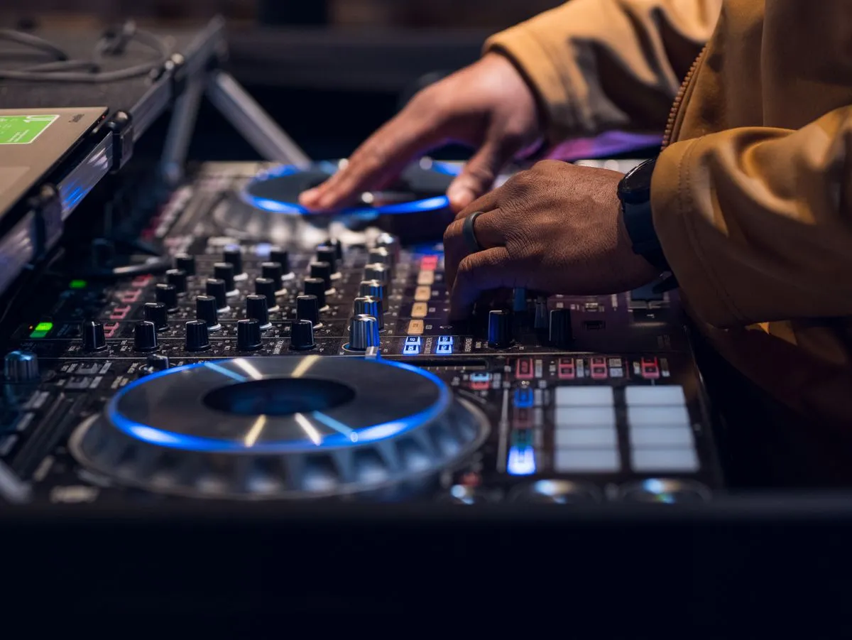 Manos del DJ mezclando musica en la consola