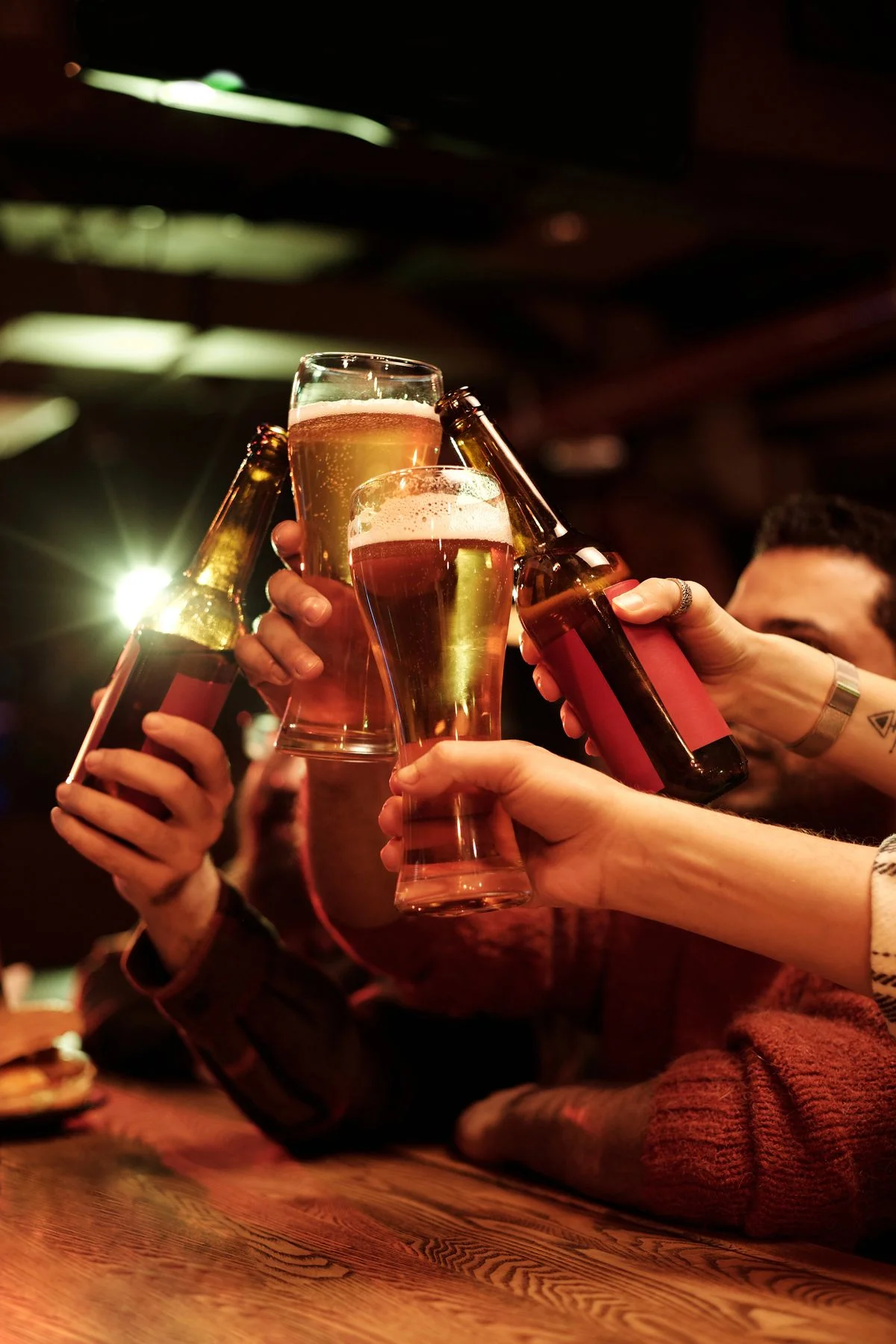 Amigos brindando con cervezas en un bar, celebrando juntos