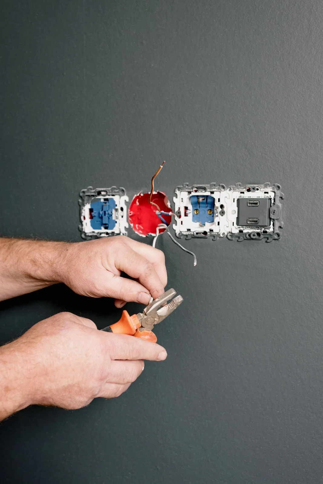 Manos de electricista con herramientas trabajando en una instalación