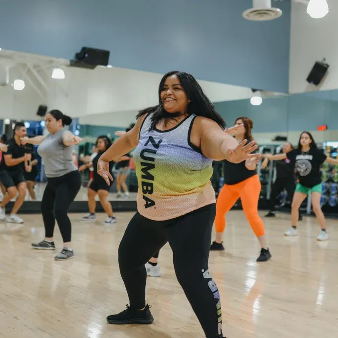 Instructora latina de zumba dando clase frente a sus alumnas
