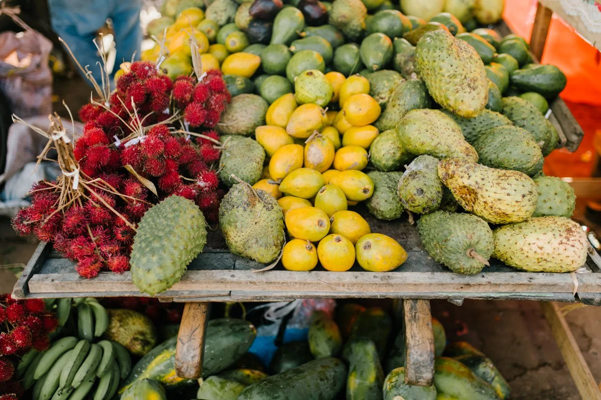 Frutas tropicales apiladas y brillantes a la venta