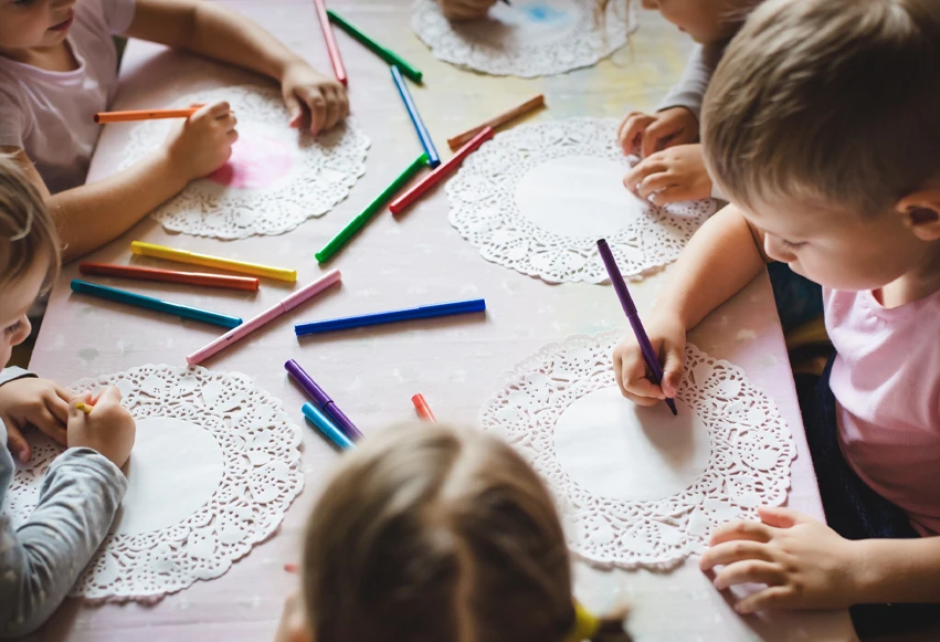 Niños dibujando y haciendo manualidades en la guardería