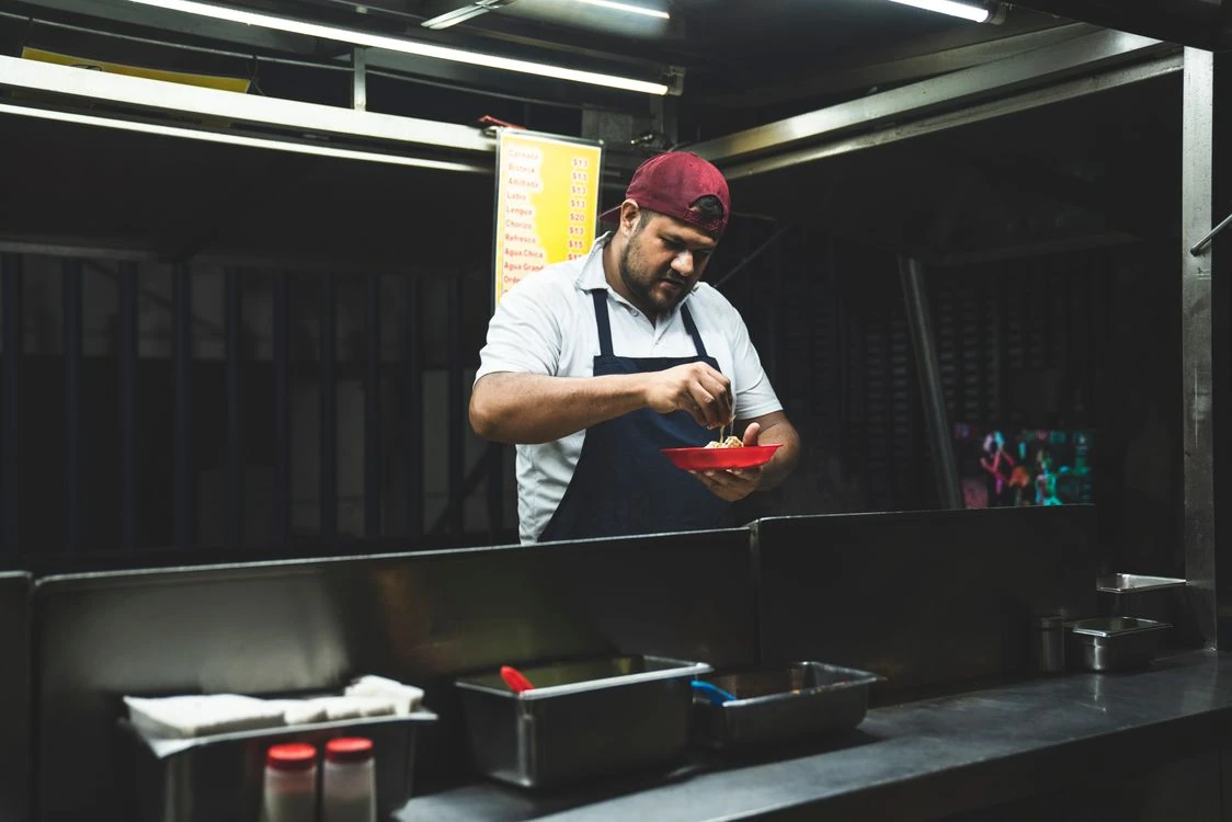 Taquero latino atendiendo su puesto de noche