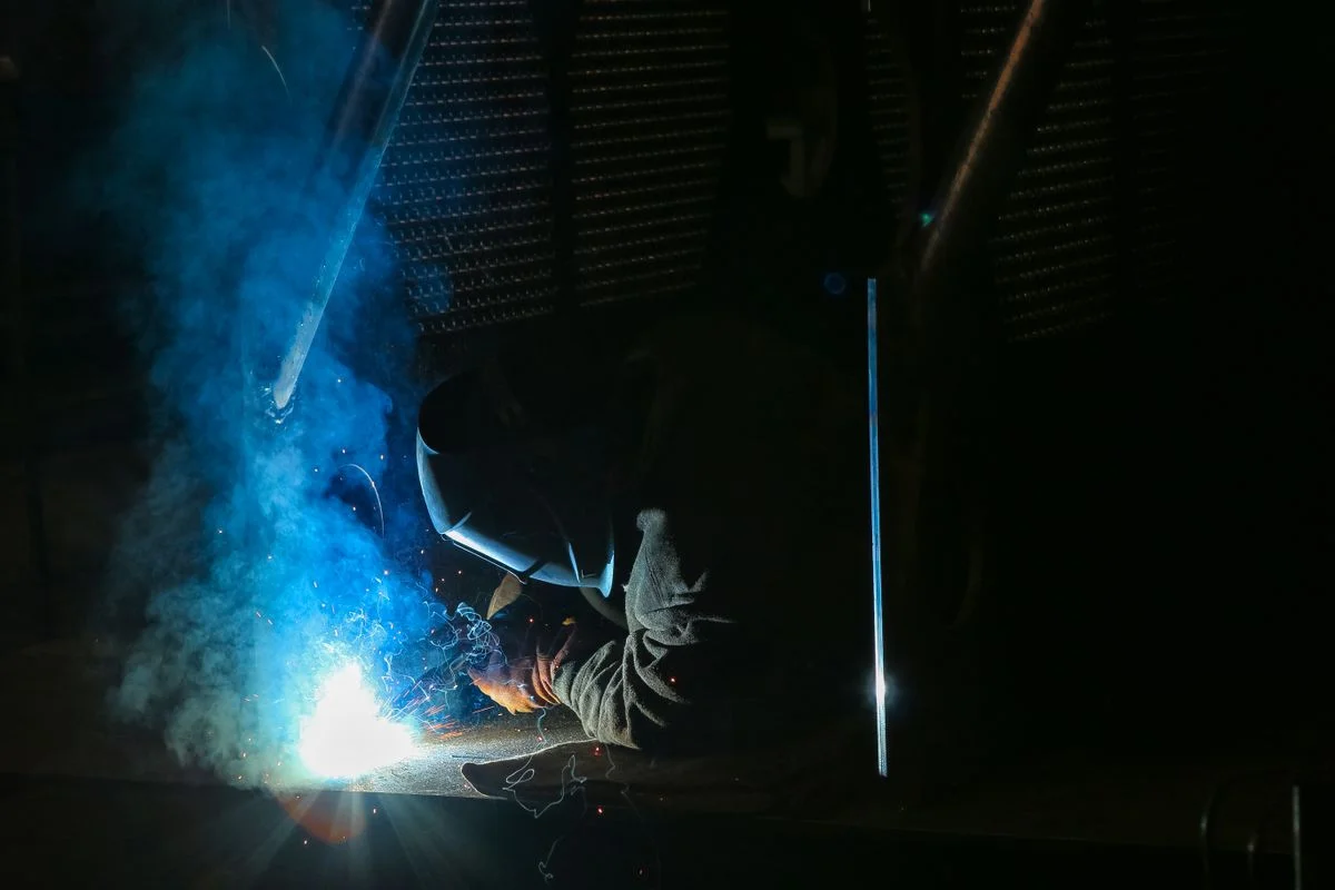 Soldador trabajando de cerca con chispas