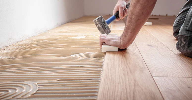 Trabajador instalando piso de madera en una casa