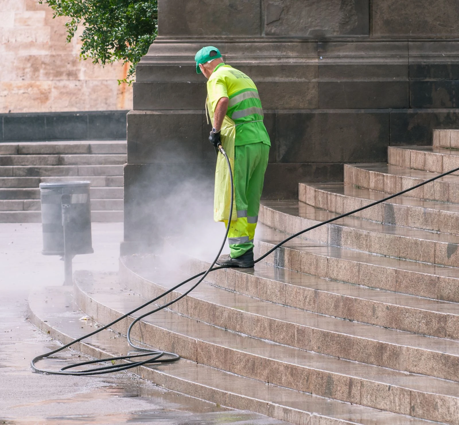Trabajador lavando a presión las escaleras de un edificio