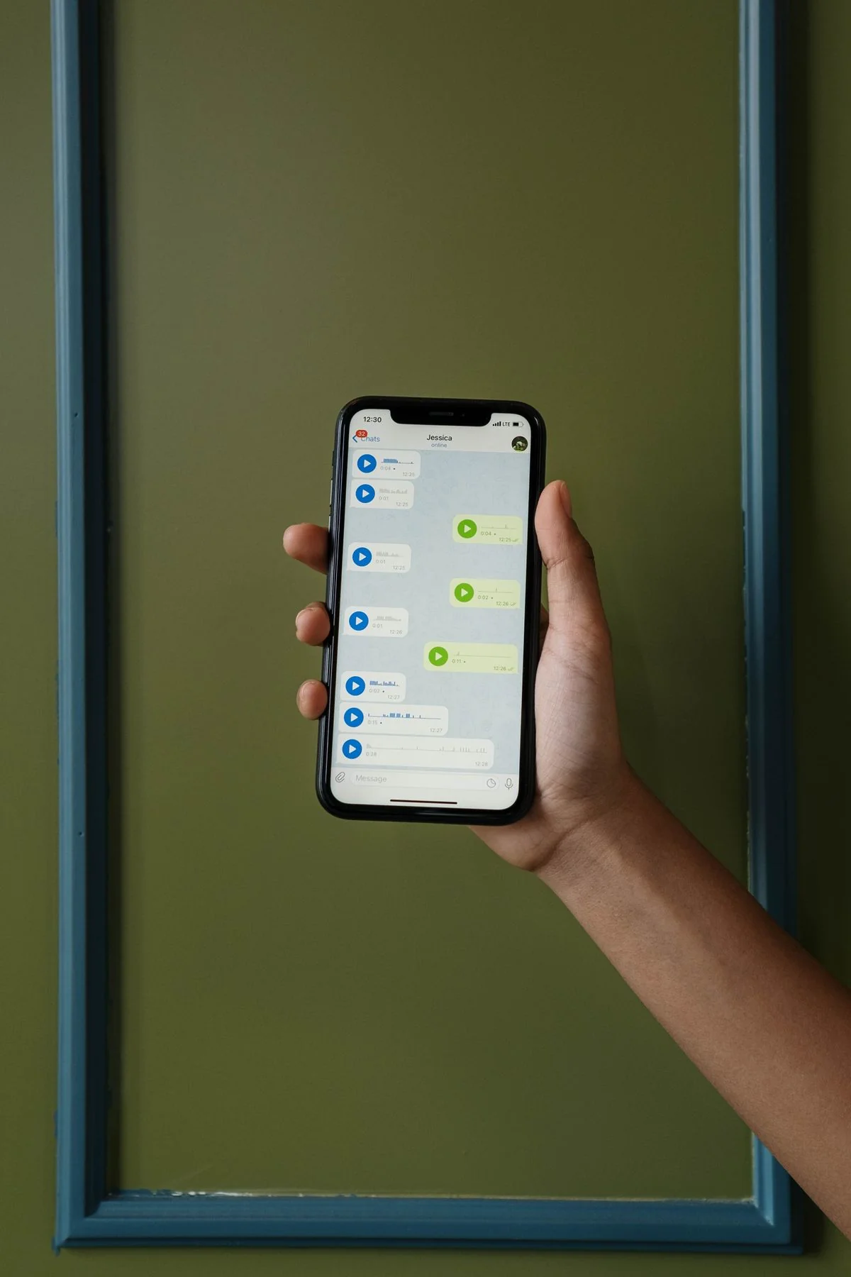 Manos sosteniendo un teléfono con WhatsApp abierto en un negocio latino de Memphis