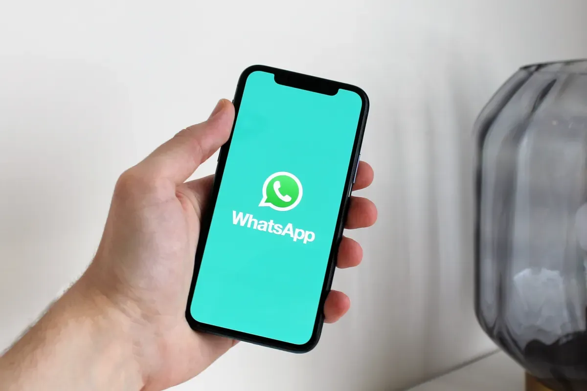 Teléfono mostrando una conversación de WhatsApp entre un negocio y un cliente