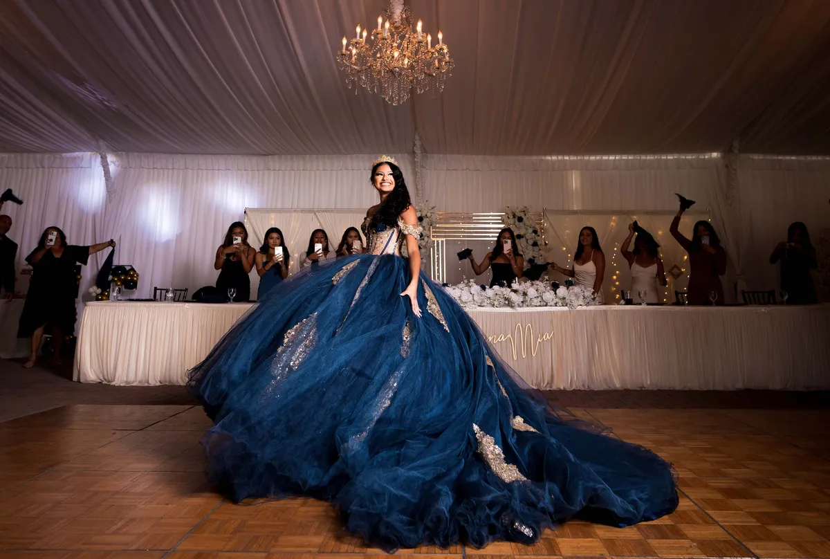 Quinceañera con vestido azul y corona en su fiesta