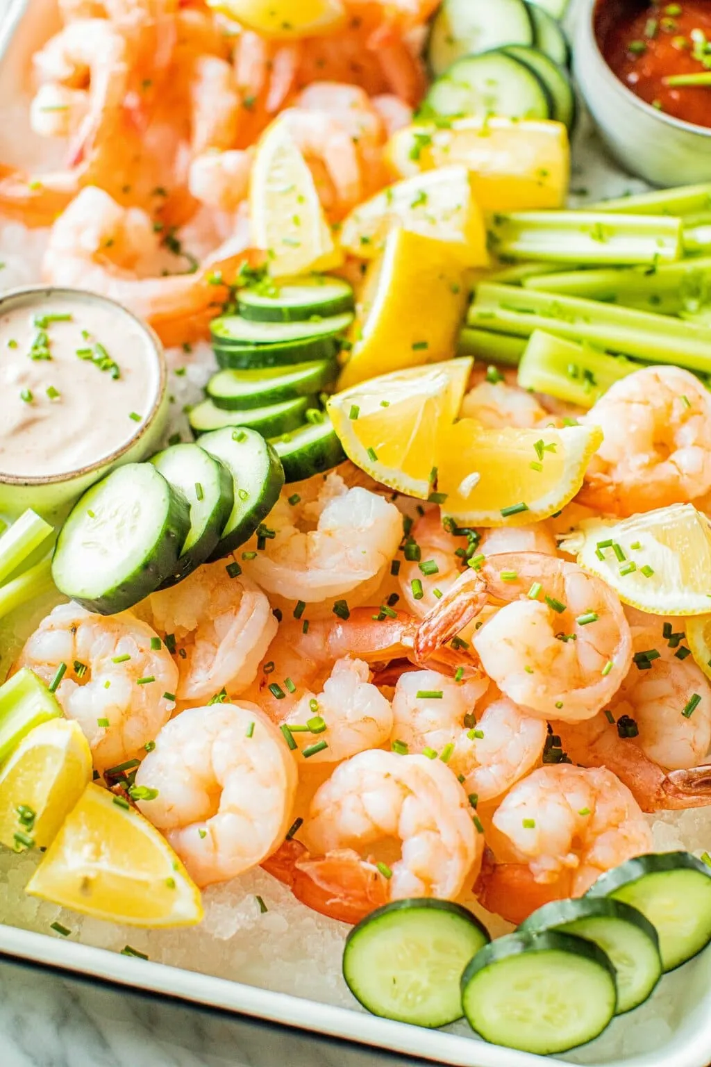 Plato de camarones cocidos con limón y salsas para compartir