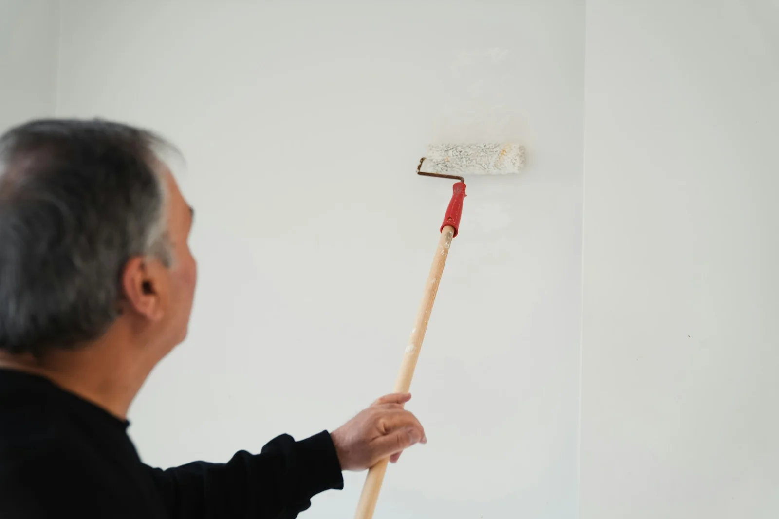 Pintor profesional pintando una pared con rodillo