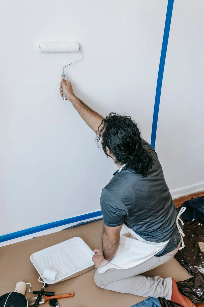 Pintor pasando el rodillo en una pared interior