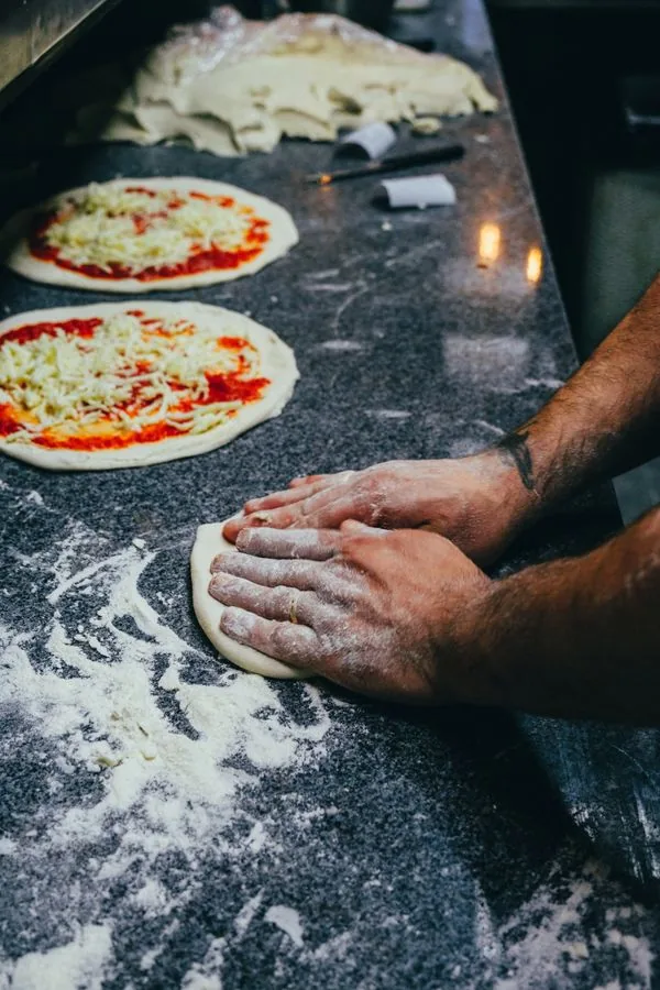 Cocinero estirando masa de pizza