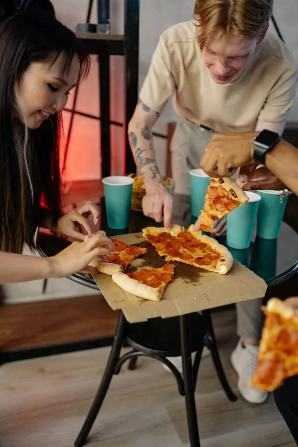 Familia comiendo pizza en la mesa de un restaurante
