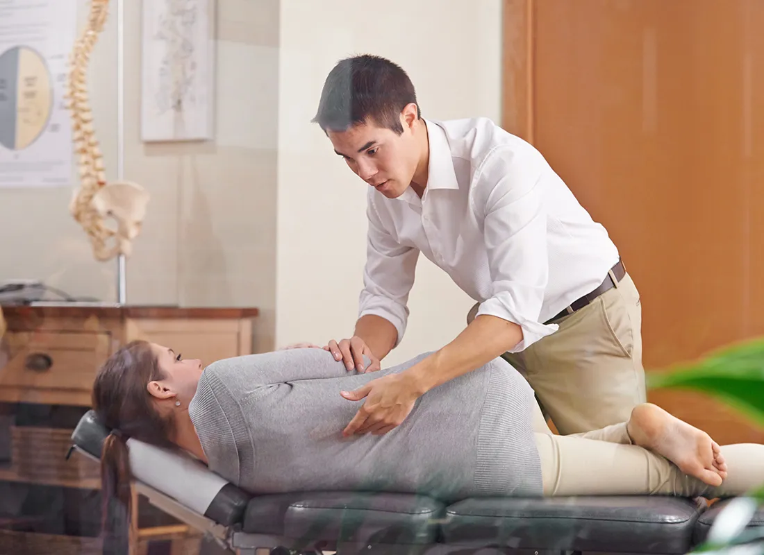 Quiropráctico ajustando la espalda de un paciente en el consultorio