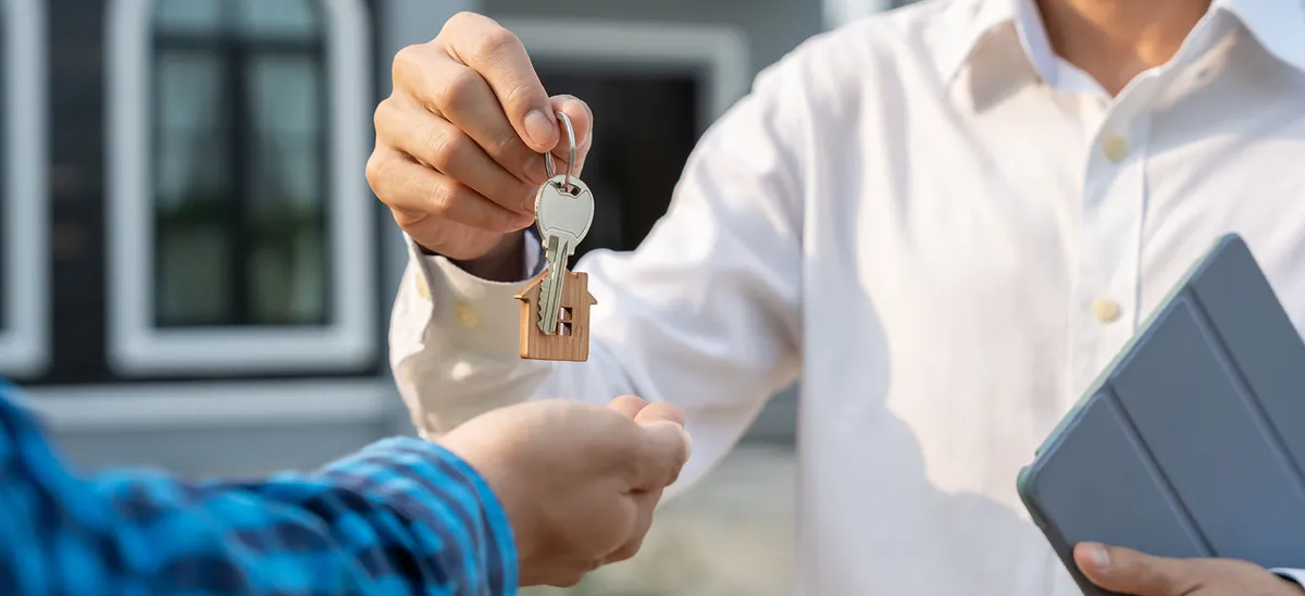Agente entregando las llaves de una casa a un comprador