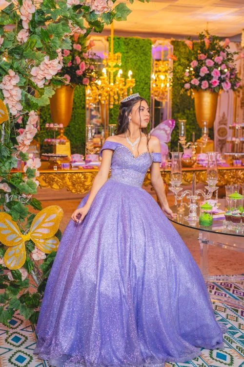 Quinceanera con vestido morado en salon de fiesta decorado