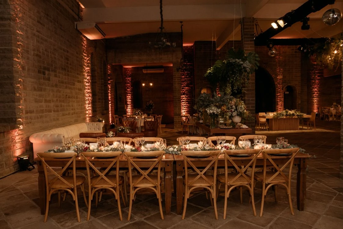 Salon de eventos con mesas de madera y sillas decoradas