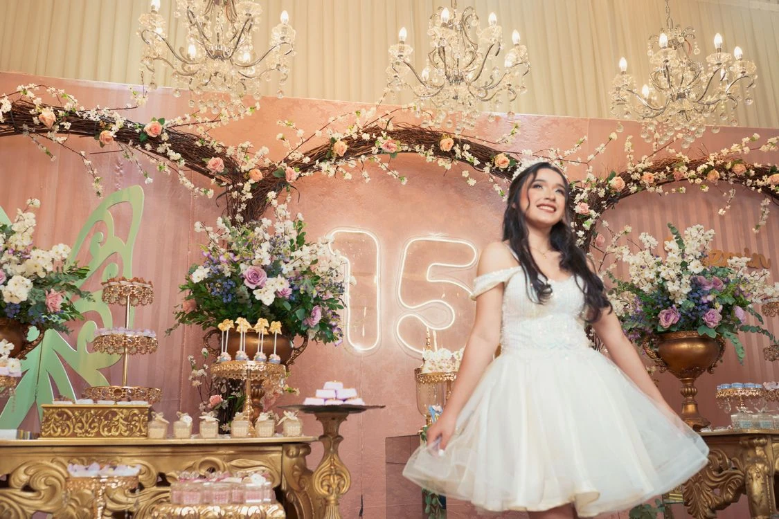 Quinceanera celebrando en un salon decorado con candelabros