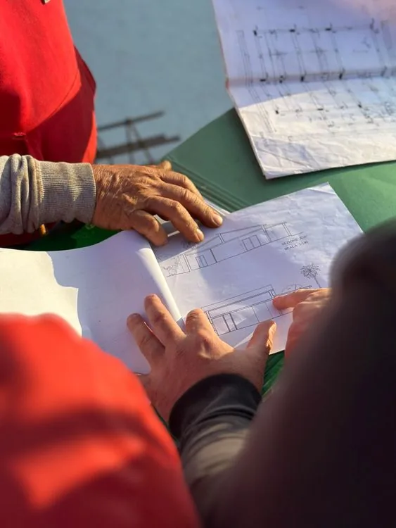Contratistas revisando planos en un sitio de construcción