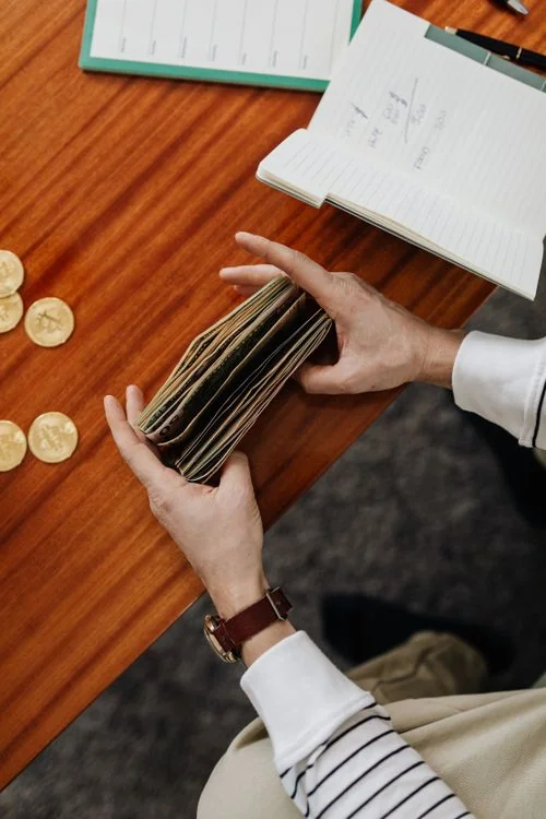 Manos contando dinero en efectivo en un negocio