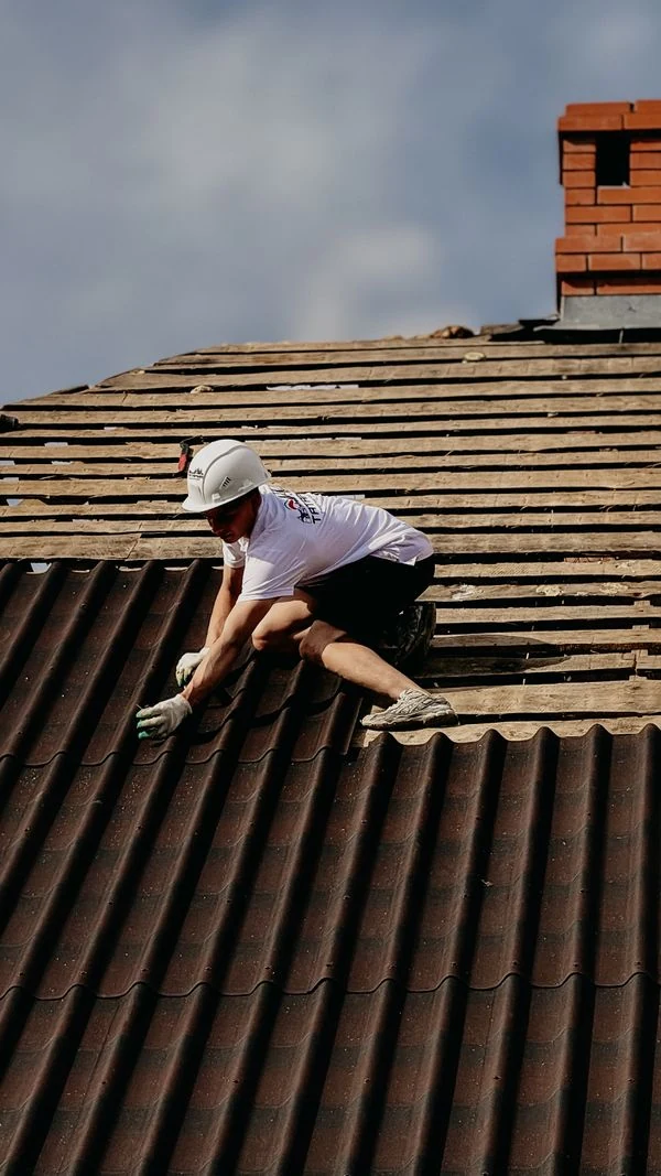 Trabajador instalando techo de lámina con casco