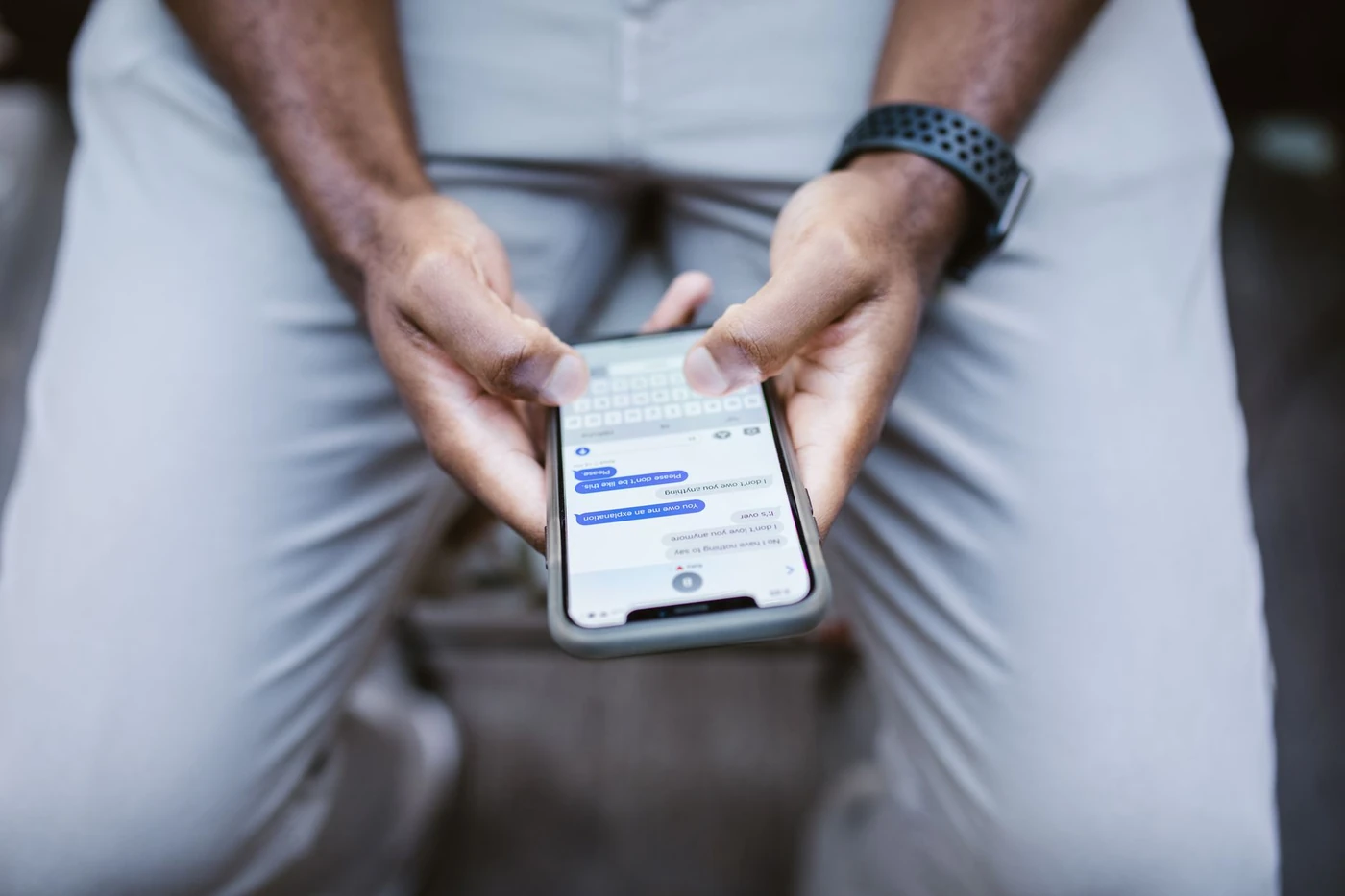 Mano sosteniendo un teléfono con mensajes de clientes en WhatsApp