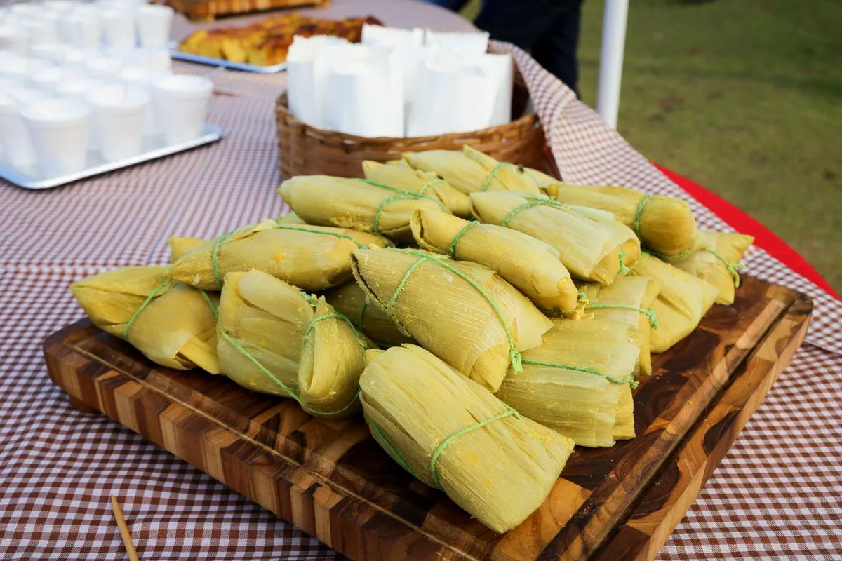 Manos preparando tamales caseros en una cocina familiar