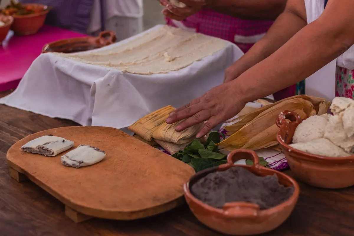 Tamalera llena de tamales calientes con vapor en una cocina latina