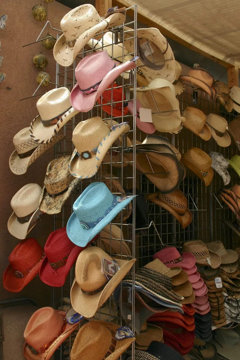 Cliente probándose un sombrero vaquero frente al espejo de la tienda