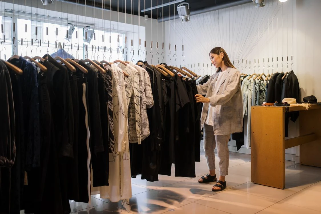 Clienta revisando ropa en los racks de una tienda