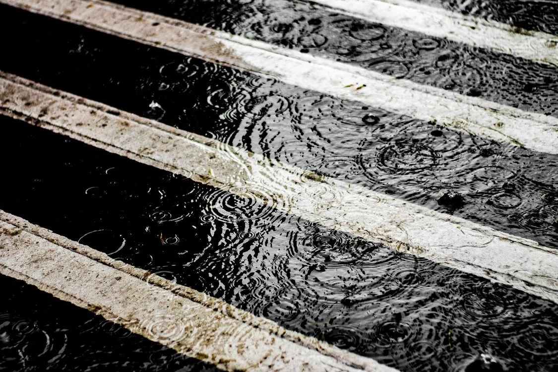 Gotas de lluvia sobre un paso de peatones mojado