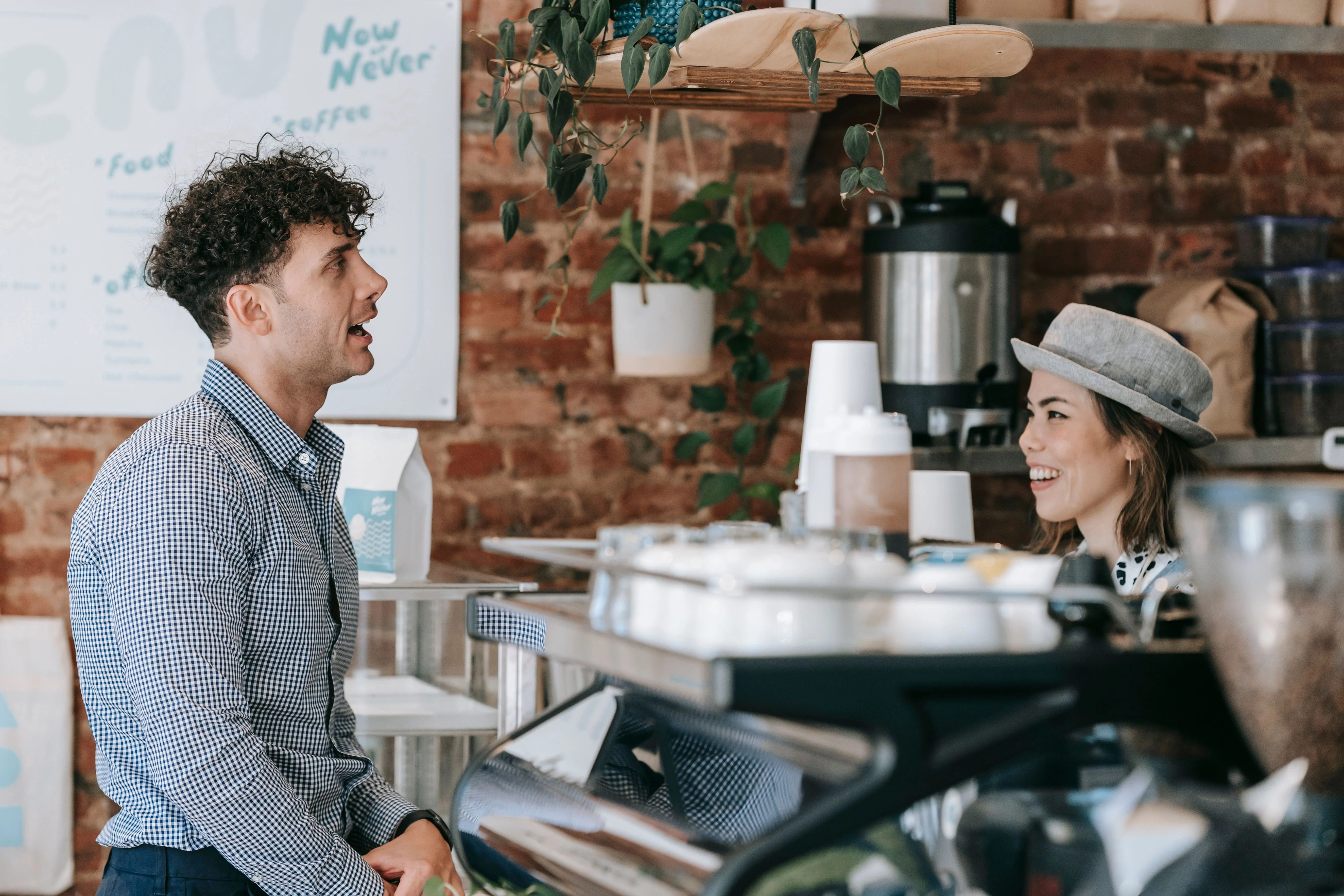 Dueño de negocio latino atendiendo con una sonrisa a su cliente