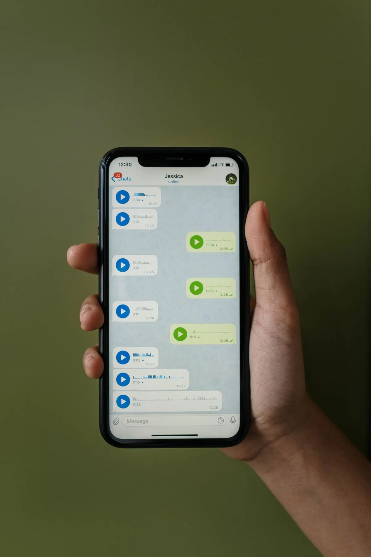Mano sosteniendo un teléfono con el chat de WhatsApp abierto