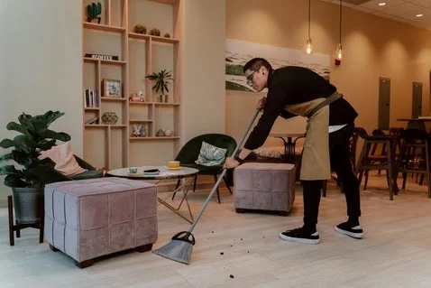 Dueño limpiando el piso de su negocio
