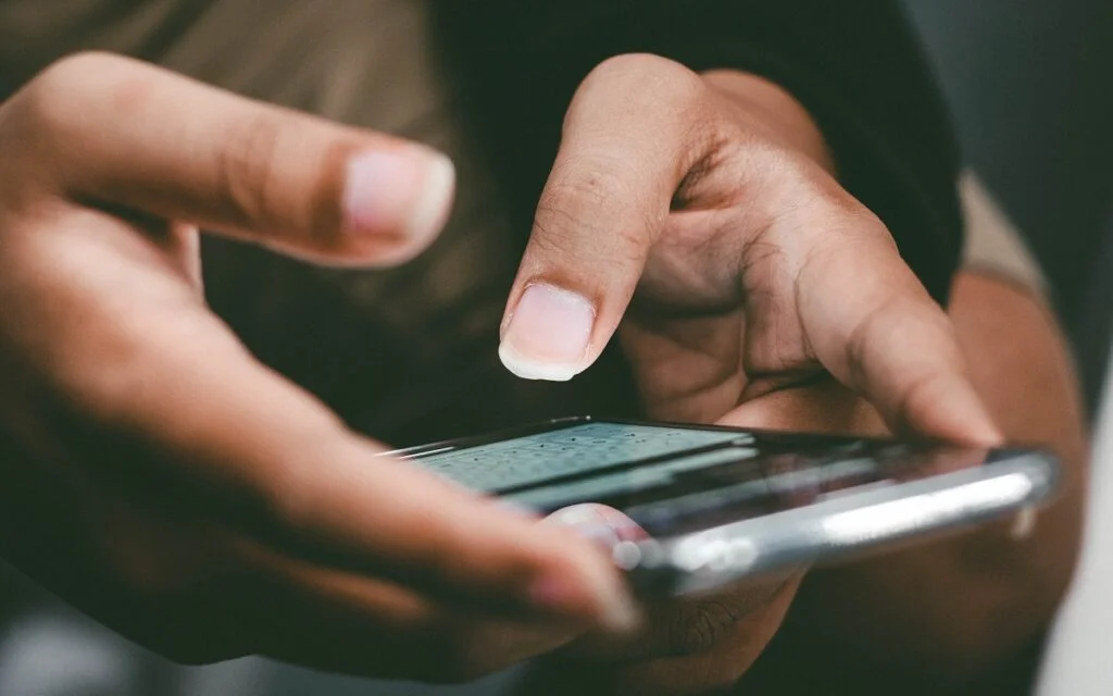 Manos escribiendo un mensaje en el teléfono